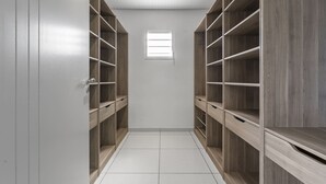 Um closet amplo com prateleiras de madeira e uma pequena janela.