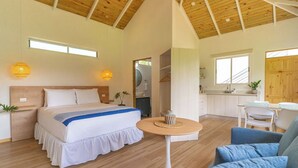 A spacious bedroom with a large bed, a round table, and a seating area.