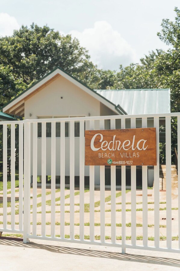 A wooden sign with the name "Cedrela Beach Villas" and a phone number. - Cedrela Beach Villas (Bahía Ballena)