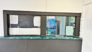A counter with a no-refund policy sign, a Pennsylvania Sheriffs' Association sign, and a vending machine with beverages.