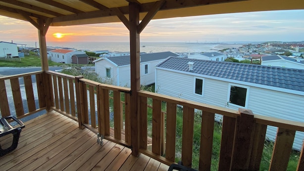 A wooden deck with a view of a beach and ocean at sunset. - Mobile home sea view high up on the Opal Coast  (Le Portel)