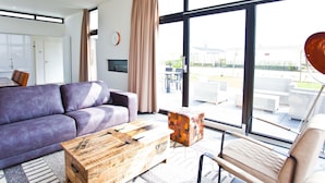 A modern living room with a purple sofa, a wooden coffee table, and a beige armchair. - Modern Holiday Home 600 m From the sea (Breskens)