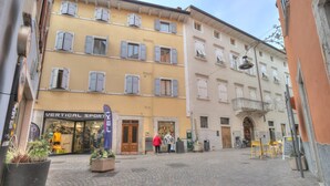 A cobblestone square with a shop named "Vertical Sport" and a building with a balcony. - Casa Arx in Arco With 1 Bedrooms and 1 Bathrooms (Arco)