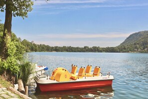 Un bote rojo con asientos amarillos amarrado a la orilla del lago.