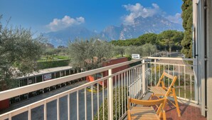 Un balcón con vista a las montañas, una silla y un letrero que dice "ALBERGO ISCHIA".