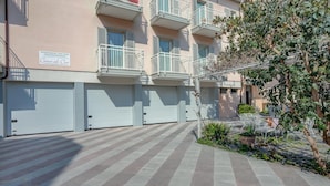Un edificio residencial con varios balcones y un camino de entrada cerrado.