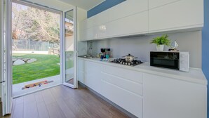 Eine moderne Küche mit einer Schiebetür aus Glas, die in einen Garten führt.