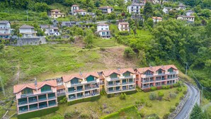 A residential area with multiple two-story houses, some with balconies, surrounded by greenery and a winding road. - Va Pensiero sul Lago Stunning View (Tronzano Lago Maggiore)