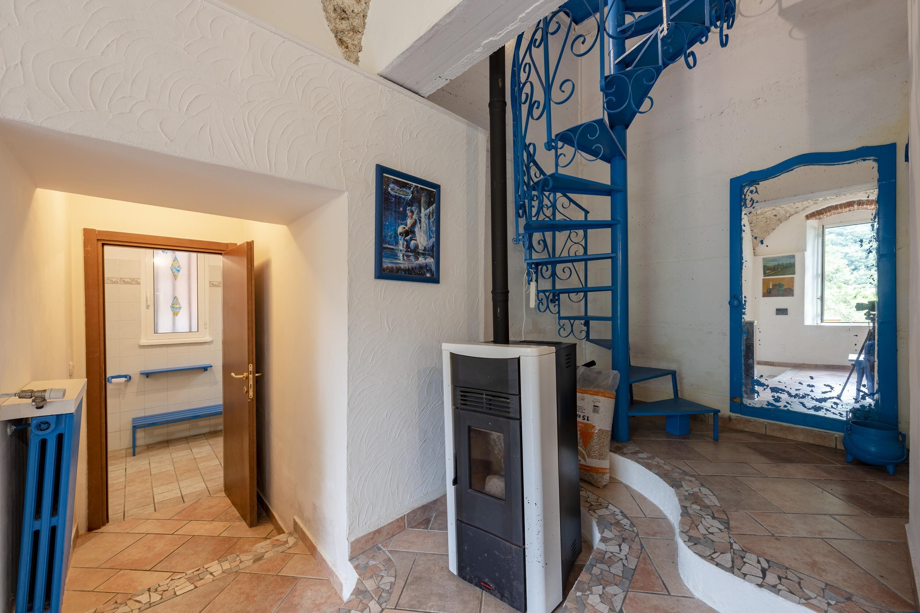 A hallway with a white wall, a blue door frame, and a white door.