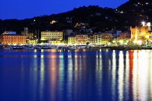 A marina with boats docked, buildings with balconies, and a castle-like structure on a hill. - Sea View Terrace In Santa Margherita (Santa Margherita Ligure)
