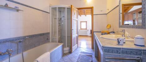 Un baño con bañera, ducha y lavabo.