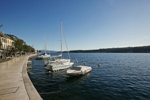 A marina with several boats docked along a waterfront promenade. - Rossella Lake View in Salo (Salò)