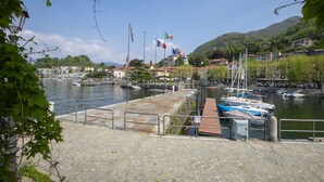 Un port de plaisance avec des bateaux amarrés, une promenade en bord de mer et des bâtiments en arrière-plan.