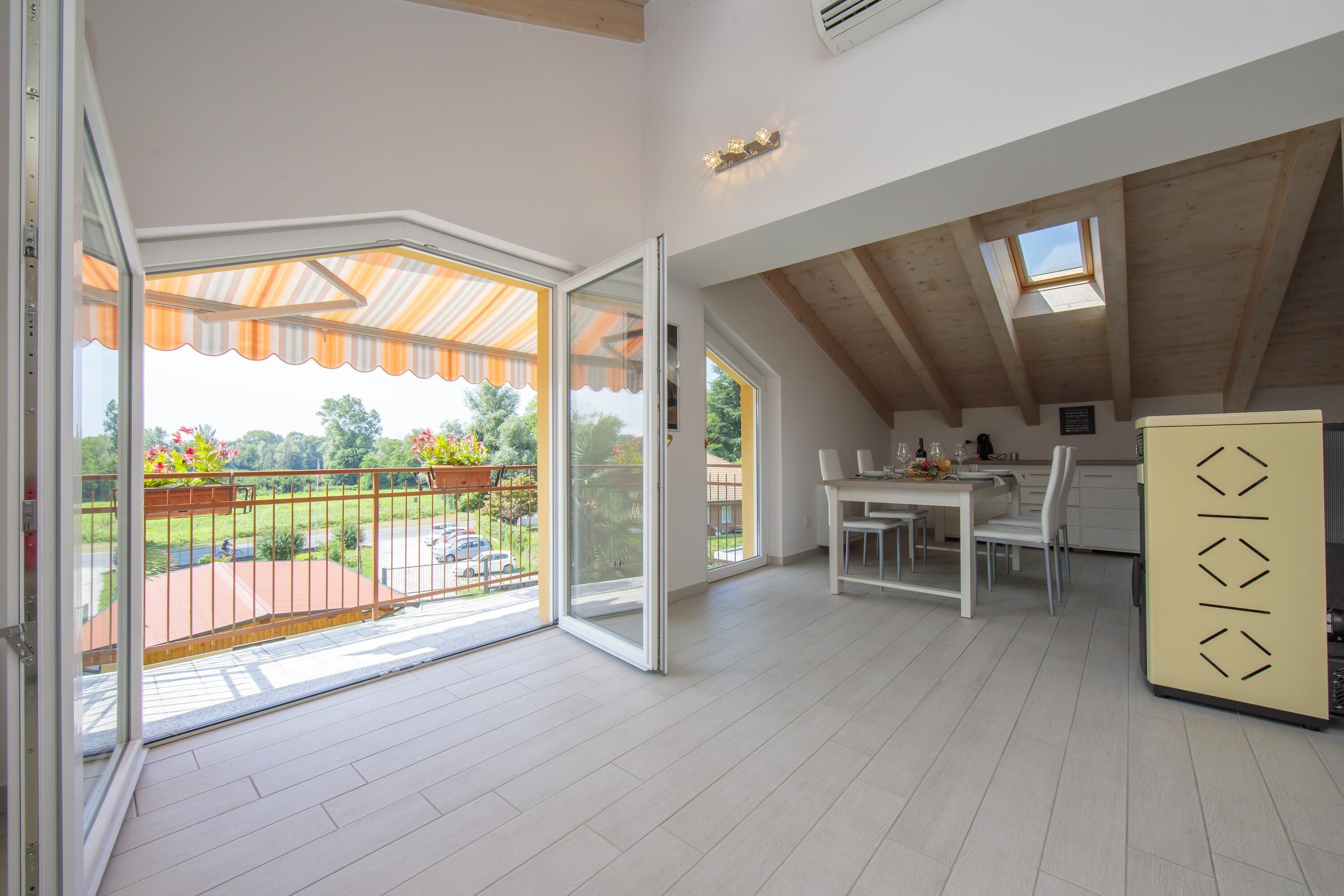 Una habitación amplia con balcón, comedor y cocina.