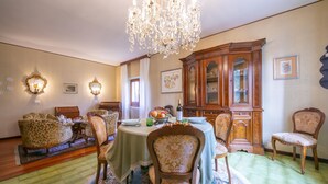 Une salle à manger avec un lustre, des meubles en bois et un tapis à motifs.