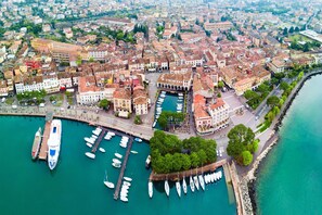 An aerial view of a coastal city with a marina, historic buildings, and a waterfront promenade. - Residenza Verde in Desenzano del Garda (Desenzano del Garda)