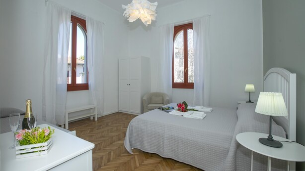 Una camera da letto con un letto, un comodino, una lampada e una sedia.