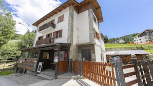 A two-story building with a wooden balcony, a sign reading "Café," and a wooden fence in front. - Miramonti 21 Ski In - Ski Out (Sauze d'Oulx)