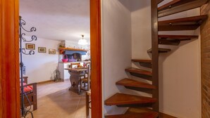 A staircase leading to a second floor, a dining area with a chandelier, and a fireplace. - Villino di Corsanico With View (Massarosa)