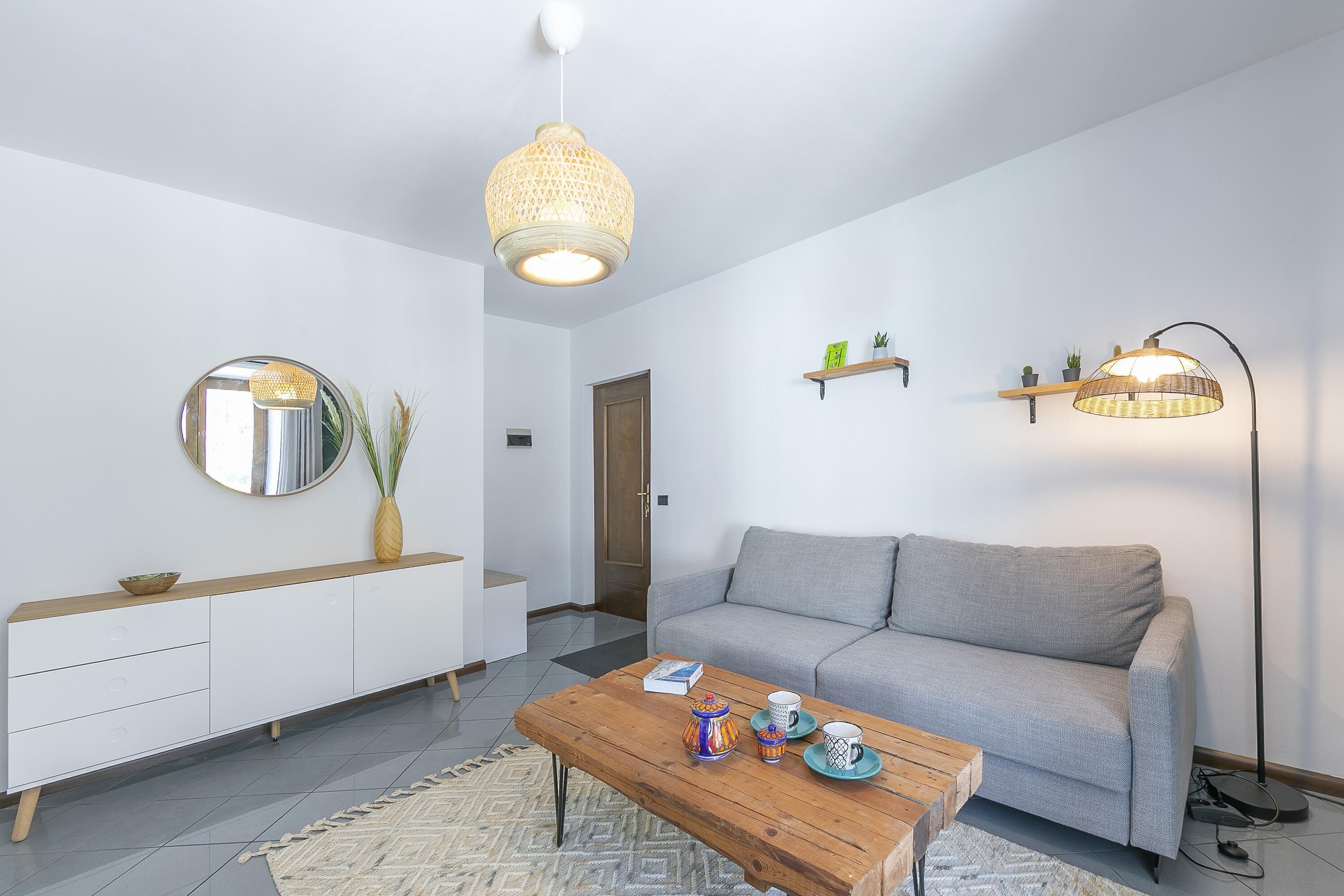 Een moderne woonkamer met een bank, salontafel en decoratieve accessoires.