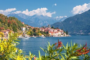 A coastal town with buildings along the water, mountains in the background, and boats on the lake. - Villa Mimosa - Appartamento 2 (Desenzano del Garda)