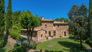 A stone house with a tiled roof, surrounded by lush greenery and a well-maintained lawn. - Villa Casacheta in Montaione (Montaione)