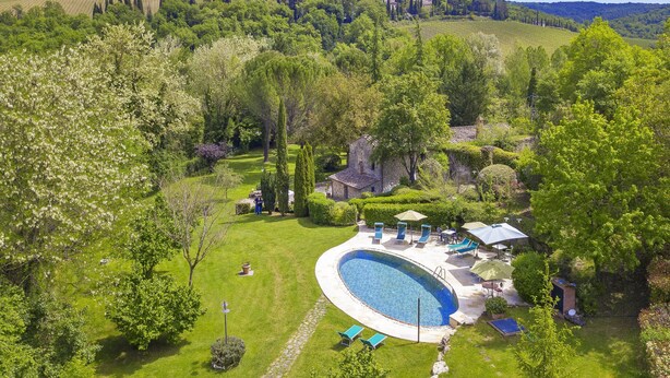 A large, oval-shaped swimming pool surrounded by a well-maintained lawn and several lounge chairs. - Molino del Ponte in Radda in Chianti (Radda in Chianti)