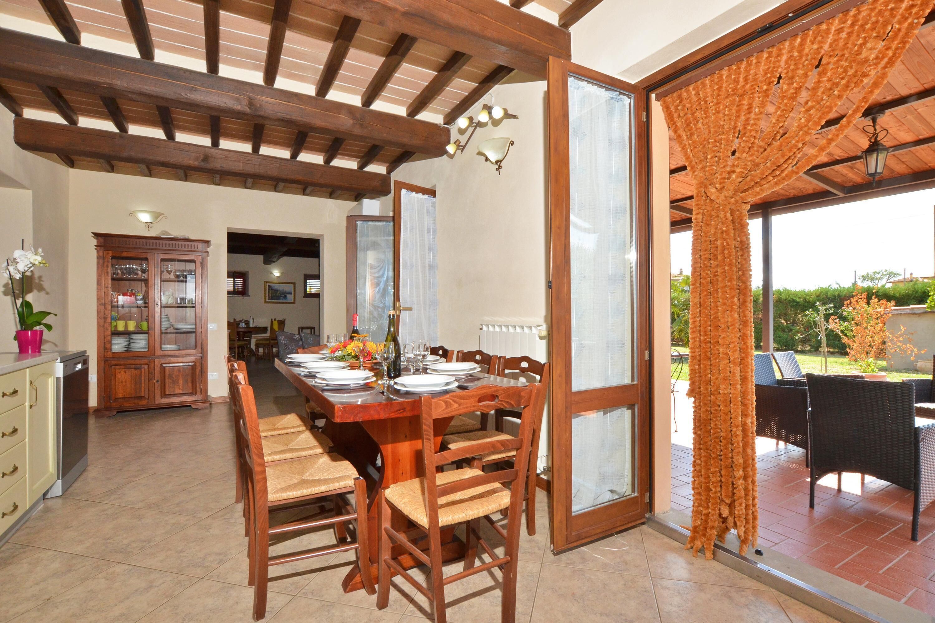 A dining area with a wooden table set for six, surrounded by chairs. A wooden cabinet with glass doors is visible to the left.