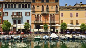 A waterfront area with buildings, boats, and outdoor seating. - Yellow Apartment Desenzano With Smart TV (Desenzano del Garda)