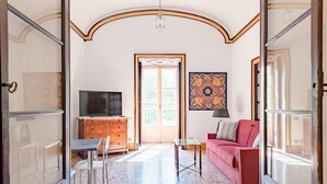 A spacious living room with a television, a sofa, a coffee table, and a decorative rug. - Nobel Flat - Historic Center (Genoa)