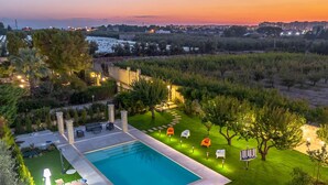 A swimming pool with a patio area, surrounded by well-maintained grass and trees. - Palazzo Biscilia in Bisceglie (Bisceglie)