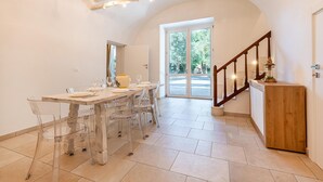 A dining area with a wooden table, clear chairs, and a wooden cabinet. - Palazzo Biscilia in Bisceglie (Bisceglie)