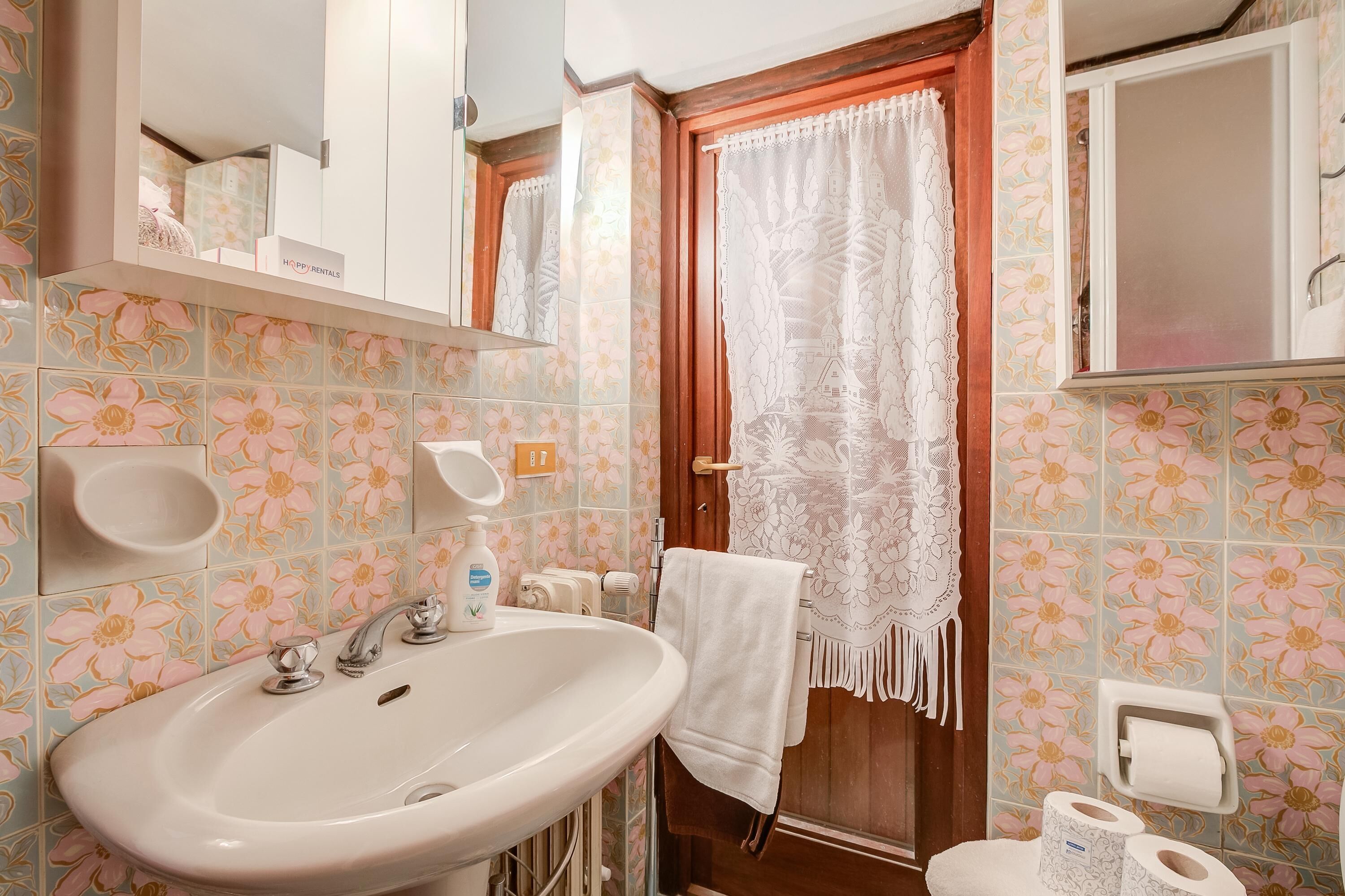A bathroom with a sink, toilet, and shower area.