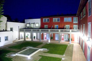A courtyard with a pool, a covered walkway, and buildings with multiple windows and doors. - Palagio 11 in Chianti With Shared Pool (Rignano sull'Arno)