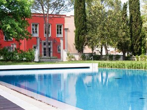 A swimming pool with a red building in the background. - Palagio 11 in Chianti With Shared Pool (Rignano sull'Arno)