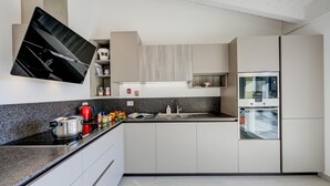 Een moderne keuken met een ingebouwde oven, een magnetron en een groot kookeiland met een spoelbak.