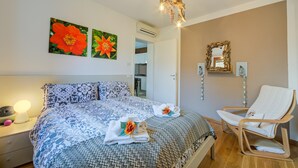 A bedroom with a bed, a chair, and artwork on the wall. - The Peace Of The Lake (Arco)