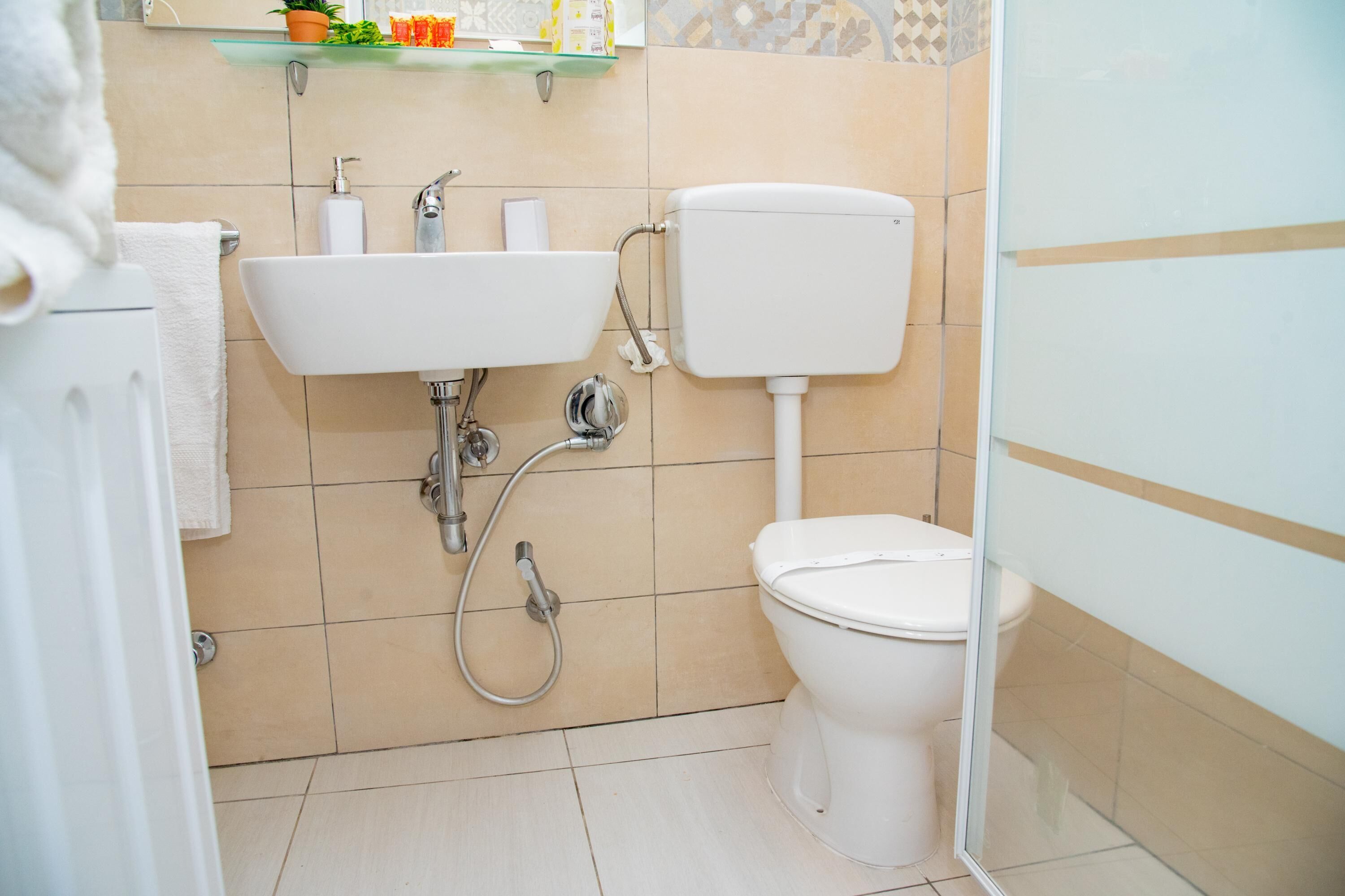 A bathroom with a white sink, toilet, and shower.