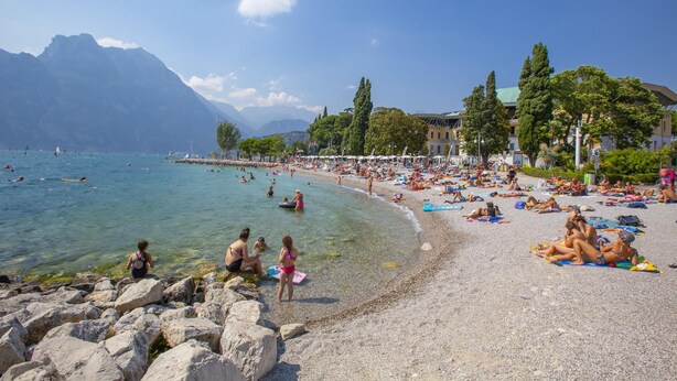 A beach with clear waters, rocky shore, and mountains in the background. - Muri Di Arco in Arco (Arco)