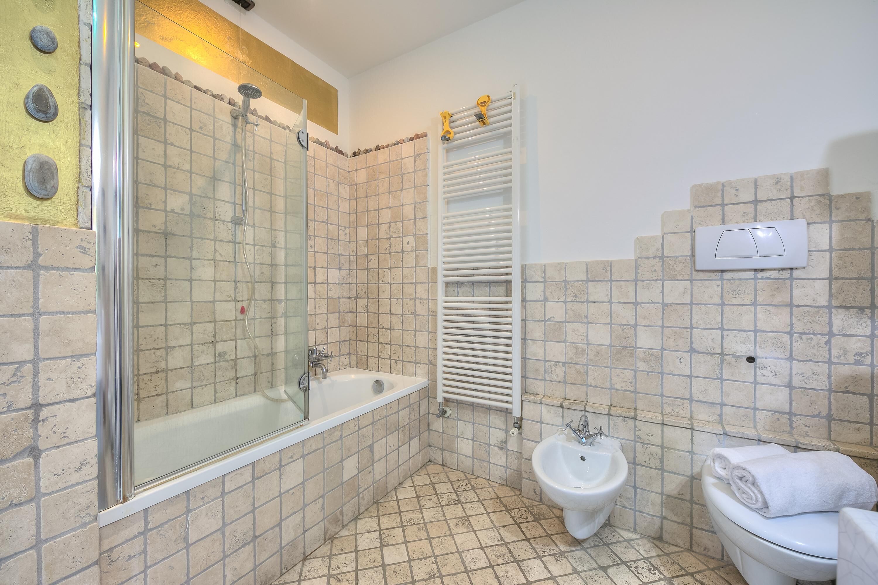 Un bagno con doccia vetrata, una vasca, un bidet e un water.