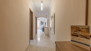 A hallway with a wooden reception desk, framed pictures on the wall, and a sign for Happy Rentals. - Merill Pool and Sea Charming Apart 1 (Mellieha)