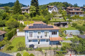 Un immeuble résidentiel doté d’un balcon, de panneaux solaires et d’un jardin.