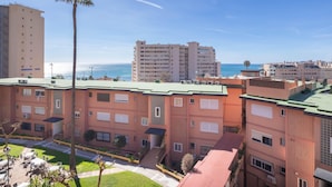 A multi-story hotel with balconies, a palm tree, and a view of the sea. - Cambural Beach Apartment (Fuengirola)