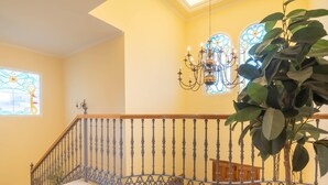 A staircase with ornate metal railings, a chandelier, and a potted plant. - Villa Carlos Mijas Golf (Mijas)