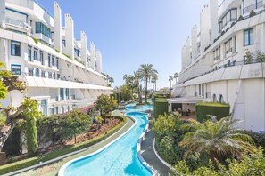 A modern hotel with a central swimming pool, surrounded by lush greenery and palm trees. - Marbella House Gf30 in Marbella (Marbella)