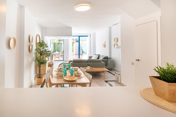 A modern interior with a dining area, a sofa, and a TV. - Marbella House Gf30 in Marbella (Marbella)