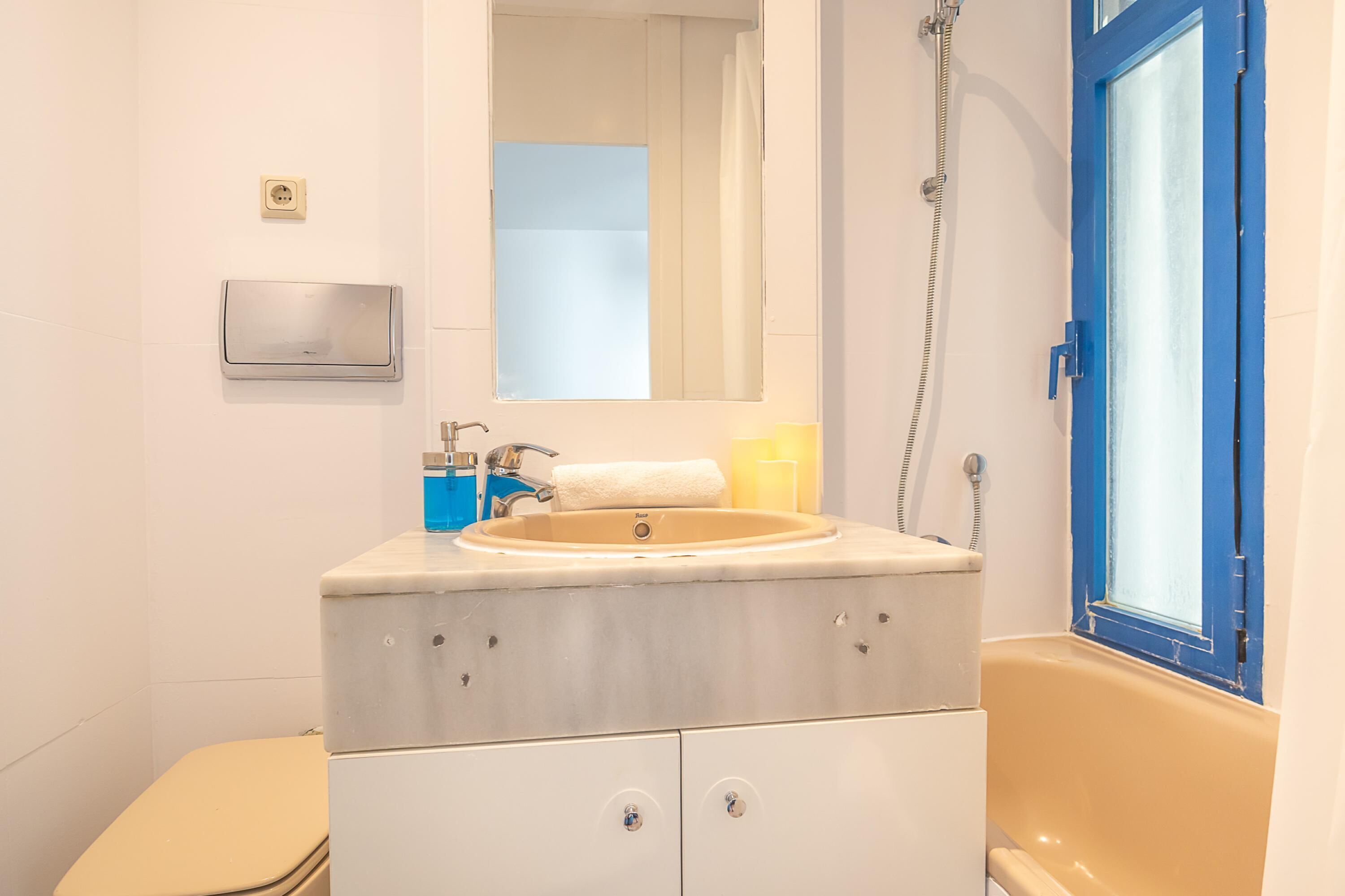 A bathroom with a sink, mirror, and bathtub.