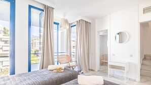 A hotel room with two beds, a desk, a chair, a round mirror, and a view of the city. - Marbella Pool House Ph24 on sea Shore (Marbella)