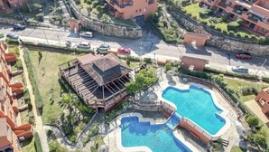 Un complejo turístico con varias piscinas, un edificio central con una escalera y villas circundantes.
