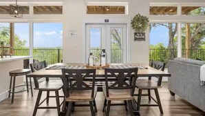 Un espace repas comprenant une grande table, des chaises et une vue sur l’extérieur.